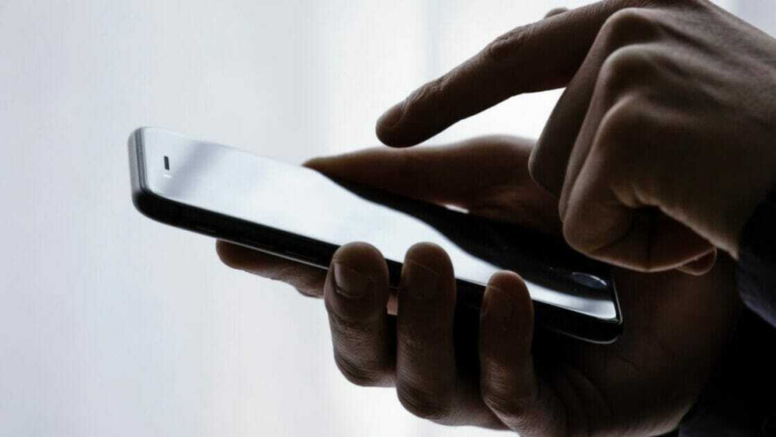 Person typing on iPhone screen