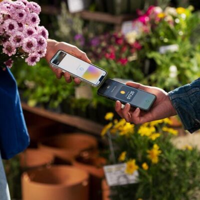 A customer uses Tay to Pay on iPhone to purchase produce at the farmer’s market.