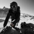 A person uses Apple Watch Ultra while climbing rocks in a mountainous setting.
