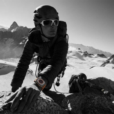 A person uses Apple Watch Ultra while climbing rocks in a mountainous setting.