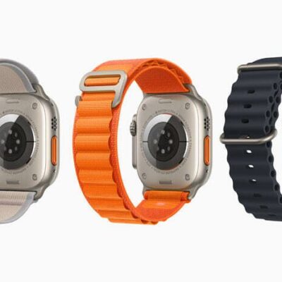 Three Apple Watch Ultra devices are shown from behind to feature their three different bands, including a gray-and-yellow Trail Loop, orange Alpine Loop, and black Ocean Band.