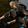 An Apple Watch user is shown riding a bicycle with Apple Watch on their wrist and iPhone mounted to the bike’s handlebars.