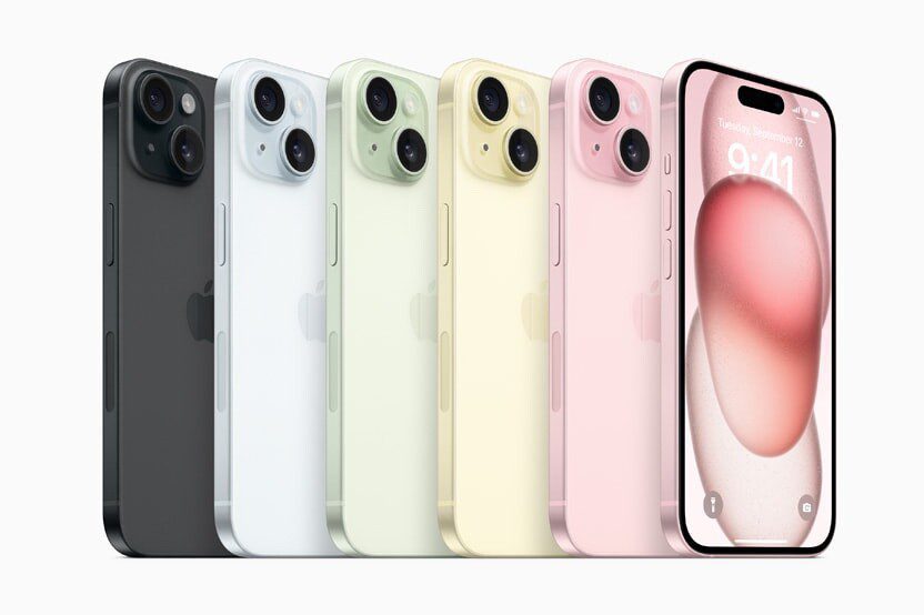 A row of iPhone 15 devices show the lineup’s new colors: black, blue, green, yellow, and pink.