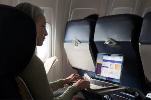 A MacBook Air user works while on a flight.