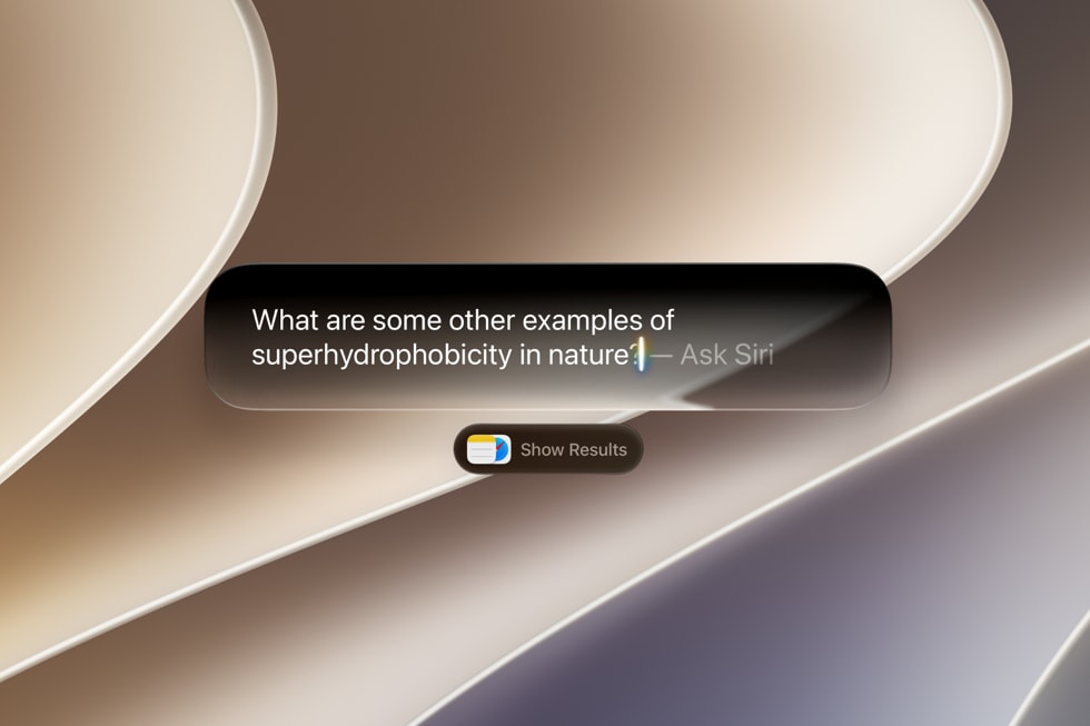 A MacBook screen showing Siri AI integrated into Spotlight, answering a question.