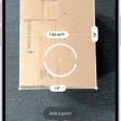 A screen showing the measurement of the dimensions of a box in the Measure app. The area of the box is calculated from the measurements of the dimensions.