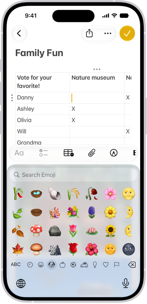 A note is open in the Notes app in the top half of the screen, and the emoji keyboard is open in the bottom half of the screen.