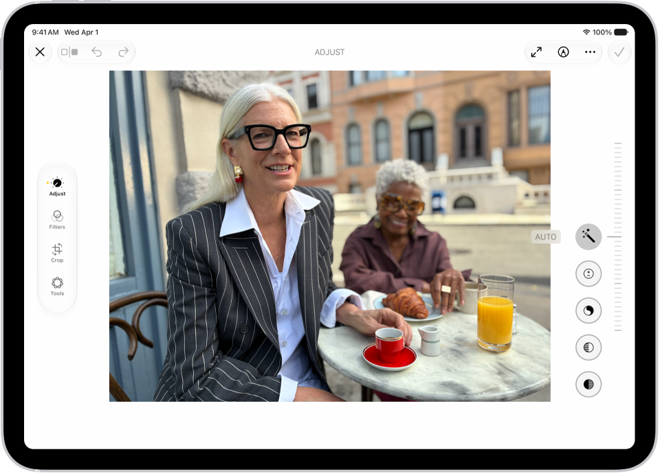 The Edit screen of the Photos app showing a photo in the center. To the left of the photo are the Adjust, Filters, and Crop buttons; Adjust is selected. To the right of the photo are buttons for editing effects and a slider to adjust each effect level.