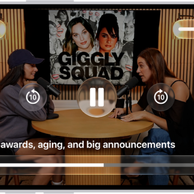 A video podcast in the Podcasts app expanded to full-screen video mode. At the top of the screen are display options and the volume control. The Skip Back, Pause, and Skip Forward buttons appear in the center of the screen. Episode details, the progress bar, and controls for playback speed, enhanced dialogue, and subtitles appear at the bottom of the screen.
