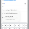 A draft email being composed. The From field is selected with two options listed below it—a personal email address and Hide My Email.