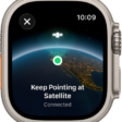A screen showing a satellite icon over a curved view of Earth, a green connection indicator, and "Keep Pointing at Satellite" text.