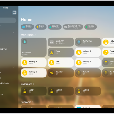 The Home app with the sidebar on the left, showing Home, Automation, and Discover tabs near the top left. Categories and Rooms in the home appear below. To the right of the sidebar, at the top, are the Intercom, Add, and More Options buttons. Category buttons appear near the top. Below that are scenes, camera images, and a room with its accessories.